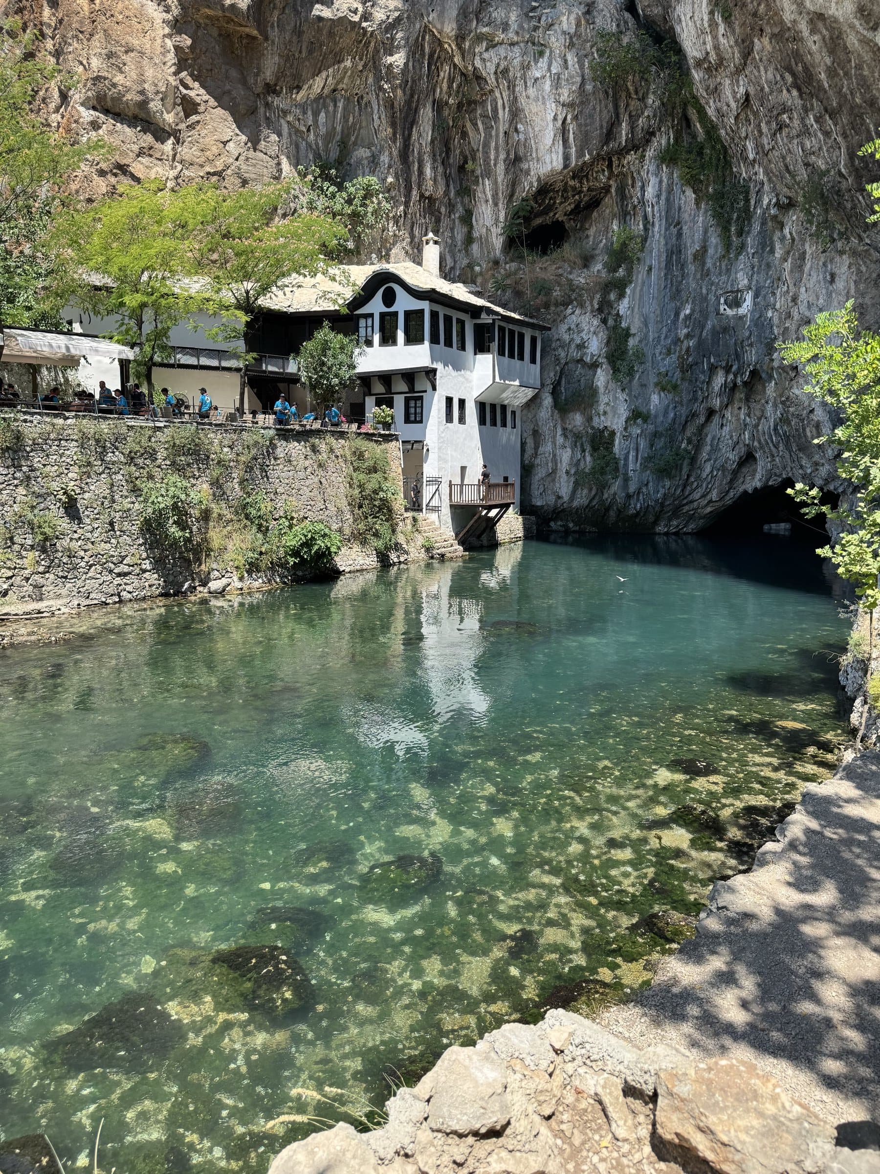 The dervish house and clear Buna water beneath the limestone cliff at Blagaj.